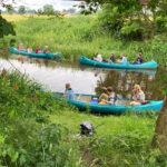Schüler:innen mit Kanus auf einem Fluss