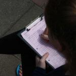 Schülerin schreibt Protokoll beim Vermessungspraktikum