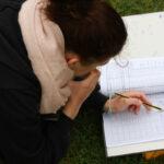 Schülerin schreibt Protokoll beim Vermessungspraktikum