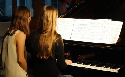 zwei Schülerinnen spielen Klavier