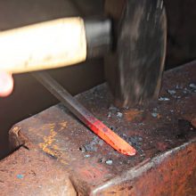 schmiedepraktikum-gluehendes-eisen-hammer glühendes Eisen und Hammer